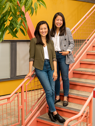 Huue founders — two people — pose on stairs